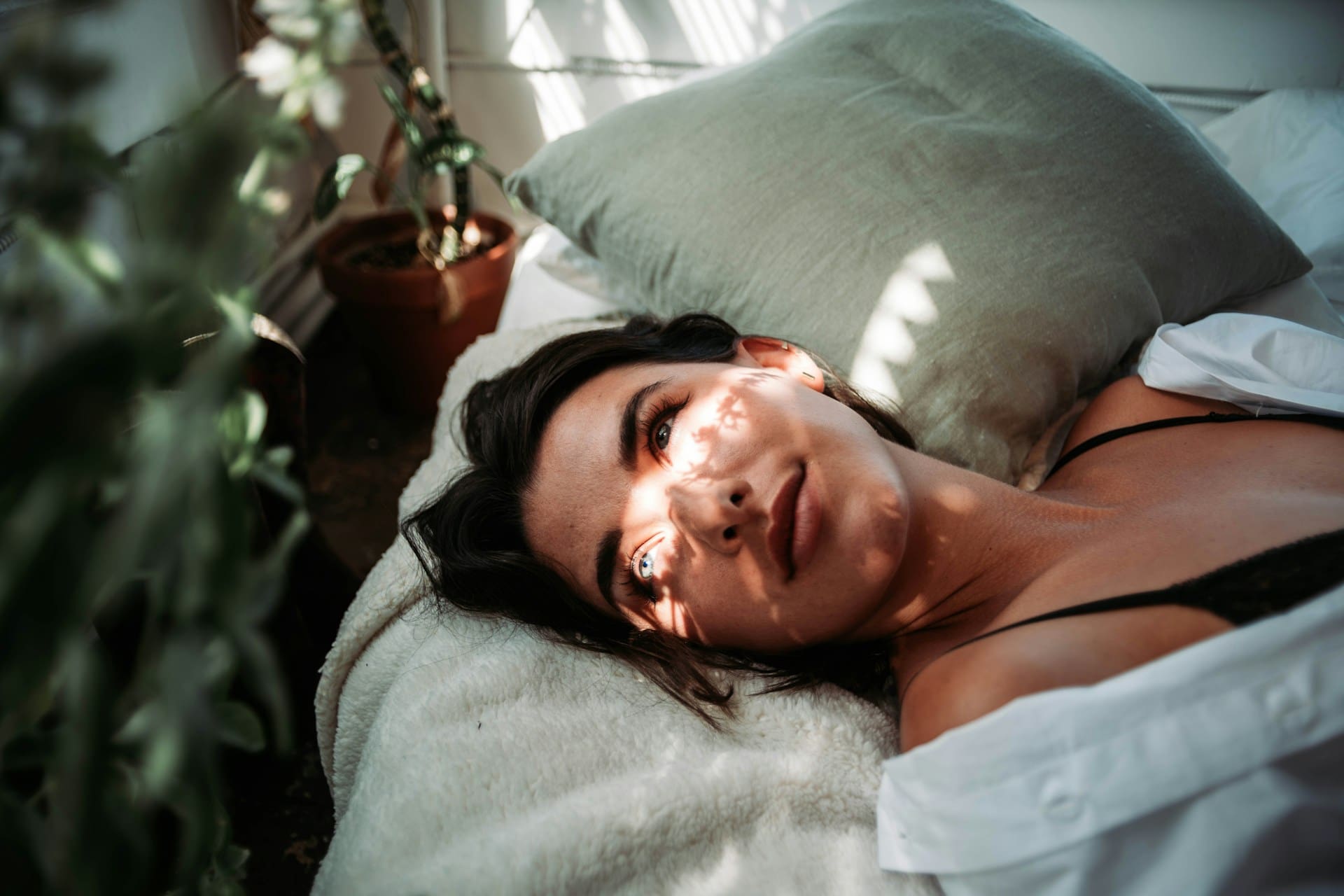 woman laying in early sunlight in bed
