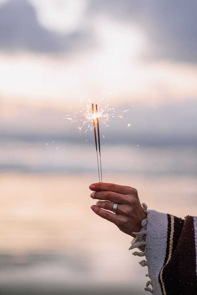 A hand holding sparkling stars on the beach